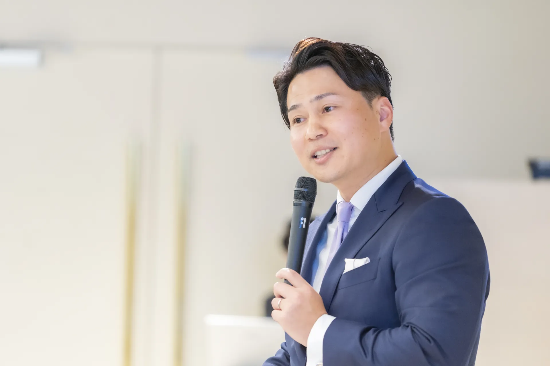 社内イベントでマイクを持って話す役員